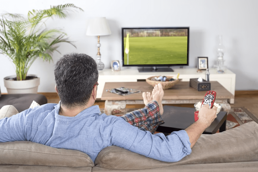 Sports fan watching a live match to determine how much they rely on commentary.