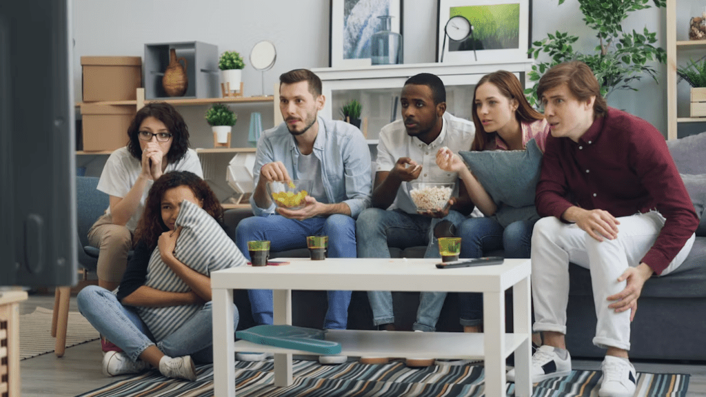 Friends watching a live sports broadcast together with shared local-language commentary.