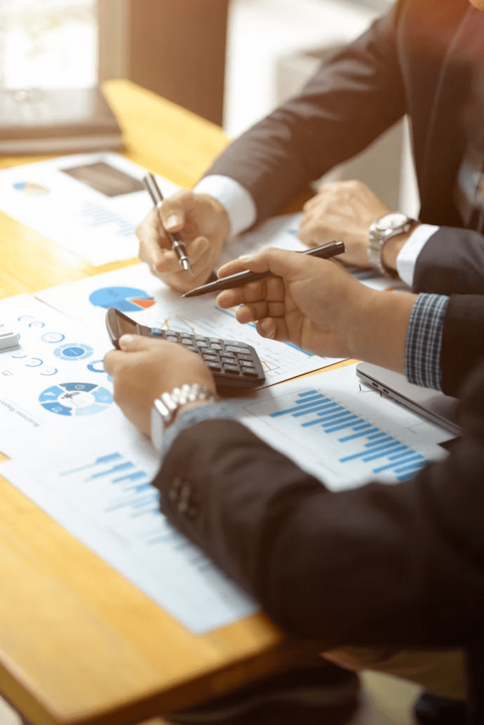 Financial analysts reviewing company reports and current business information during investment research.